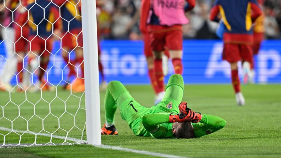 Croatia goalkeeper Dominik Livakovic lies on the pitch after Spain's victory in the penalty shootout
