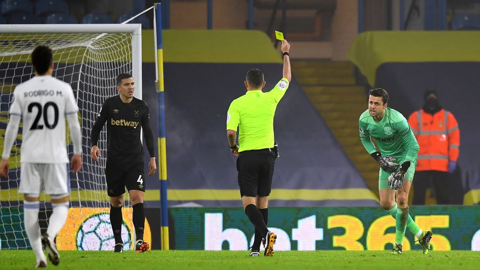 Lukasz Fabianski is shown a yellow card by Michael Oliver