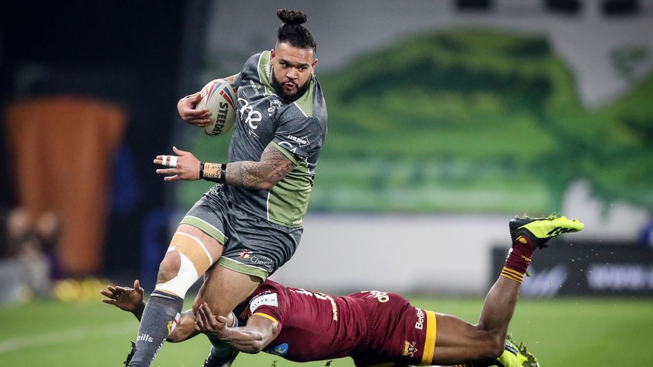 Warrington Wolves' Ben Murdoch-Masila (left) makes a break past Huddersfield Giants' Akuila Uate