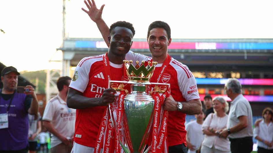Bukayo Saka and Mikel Arteta celebrate with the Premier League title
