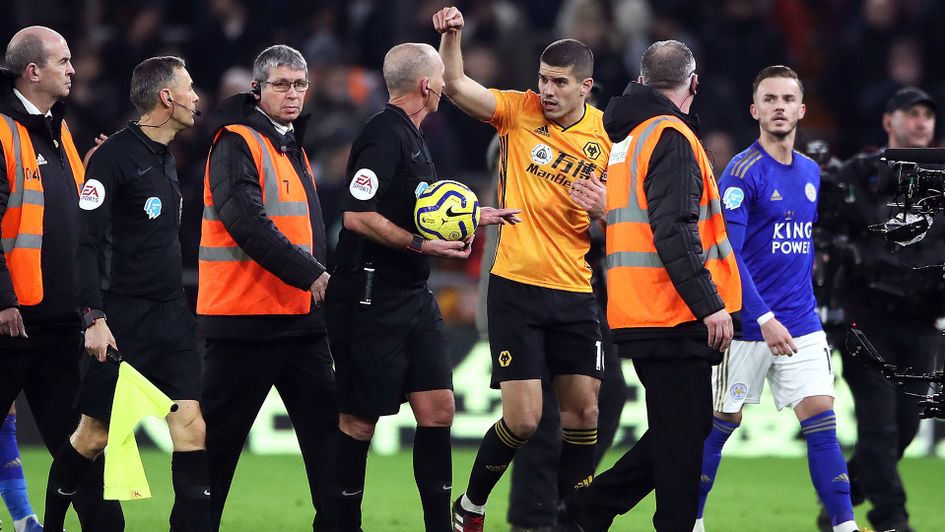 Conor Coady speaks to referee Mike Dean at half time