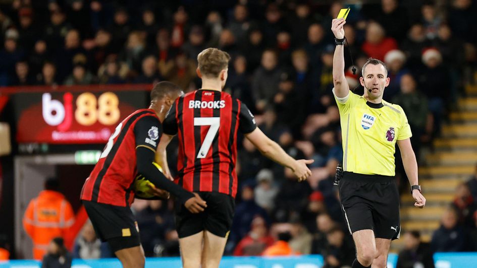 Referee Chris Kavanagh shows a yellow card to David Brooks