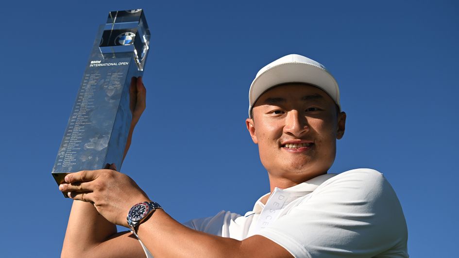 Haotong Li poses with the winner's trophy following the BMW International Open