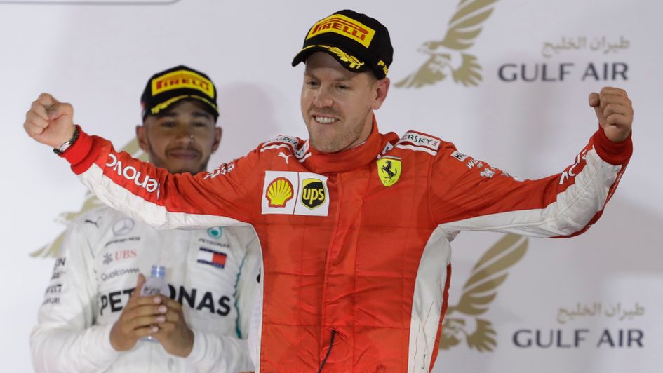 Sebastian Vettel celebrates as Lewis Hamilton looks on