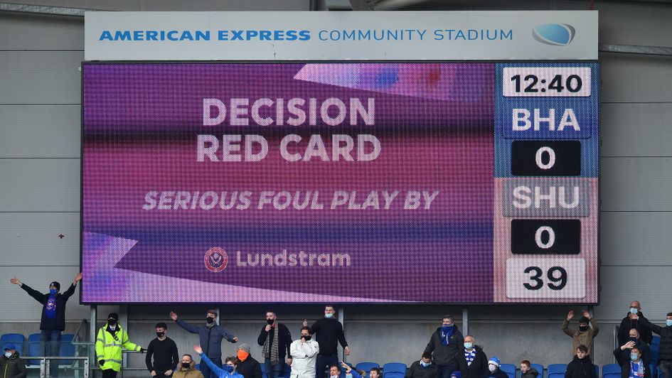 The big screen displays a VAR decision of a red card for John Lundstram
