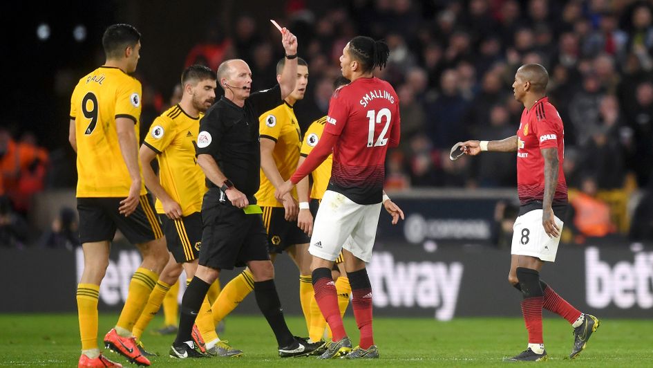 Mike Dean shows a red card to Ashley Young
