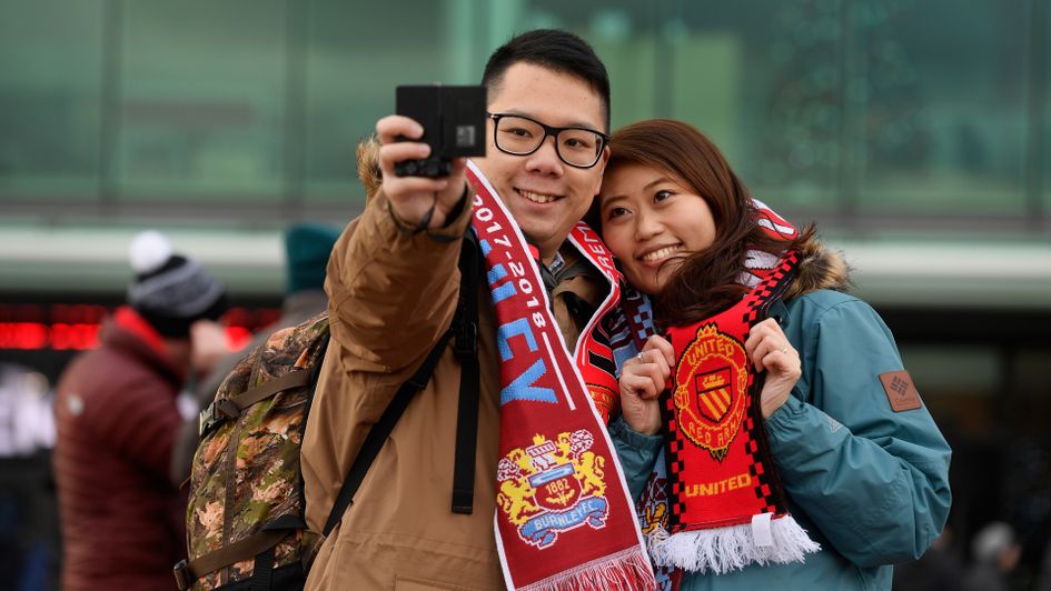 Fans pose for a picture outside Old Trafford