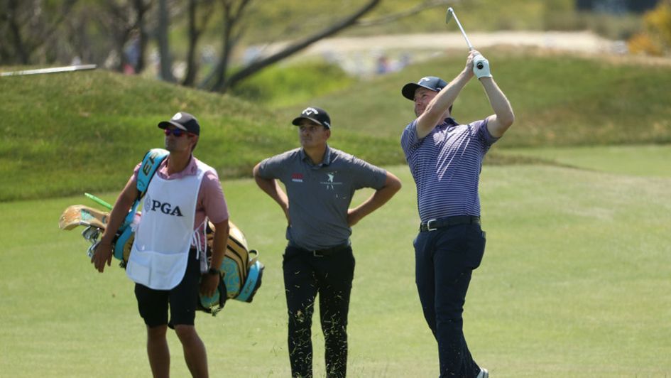 Branden Grace plays a shot as Christiaan Bezuidenhout watches on