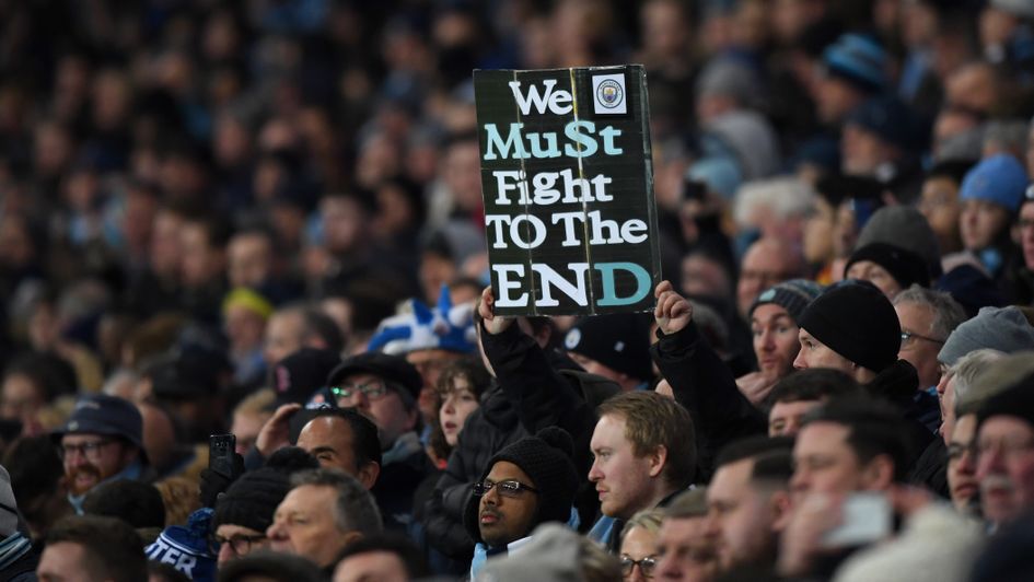 Manchester City fans hold up a sign ahead of their home game with Liverpool