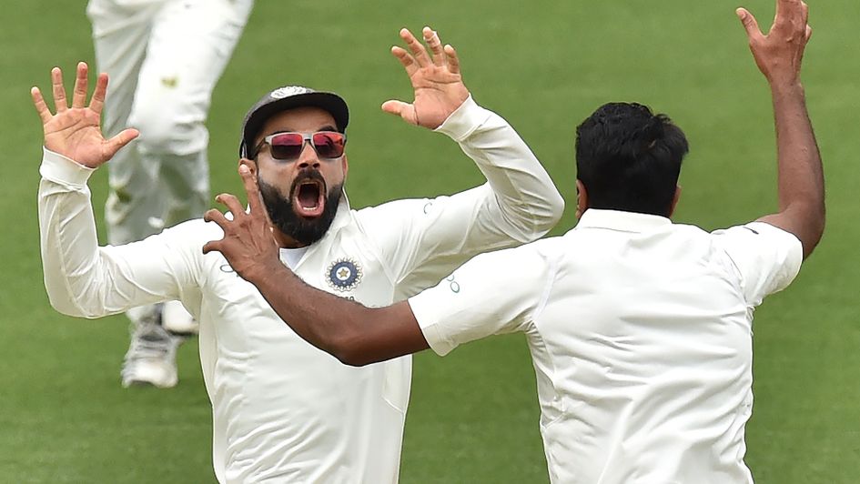India's captain Virat Kohli (L) celebrates with spin bowler Ravichandran Ashwin (R) after beating Australia