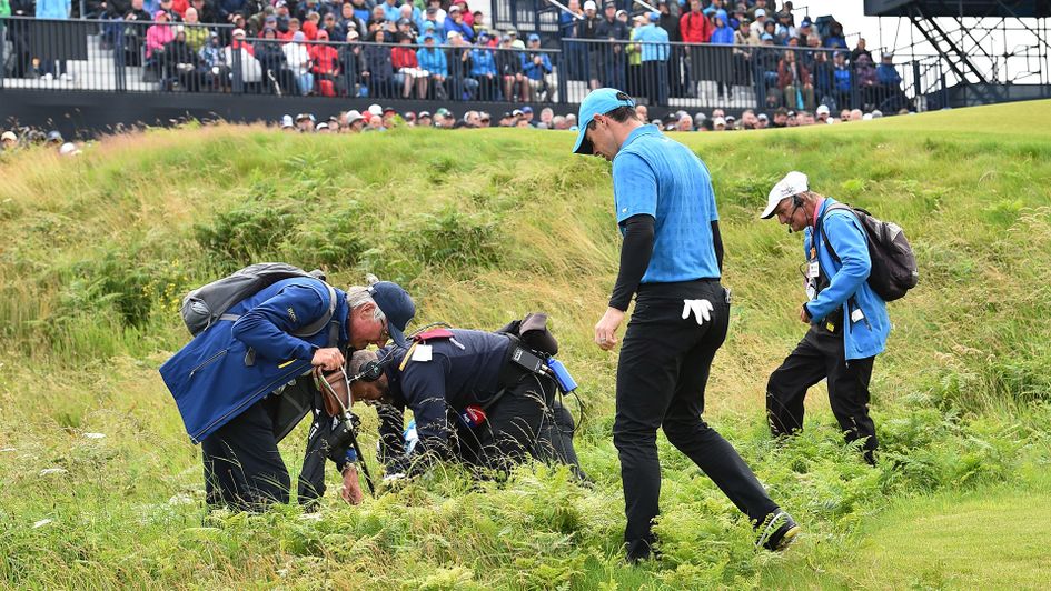 Rory McIlroy looks for his ball on the opening hole