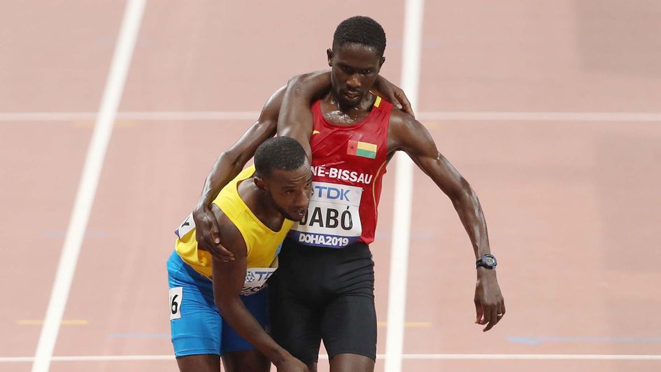 Braima Dabo helps Jonathan Busby to complete the 5,000m at the World Championships in Doha