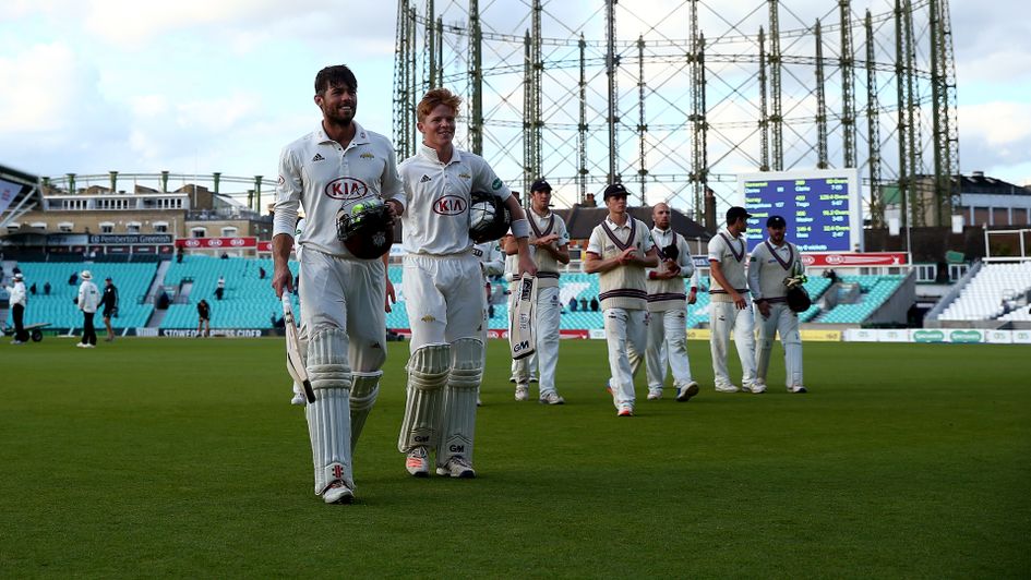 Ben Foakes and Ollie Pope of Surrey leave the field after making the final runs