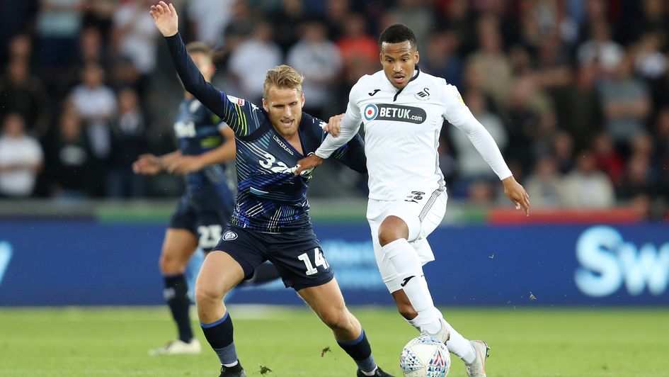 Swansea City's Martin Olsson holds off Leeds United's Samuel Saiz