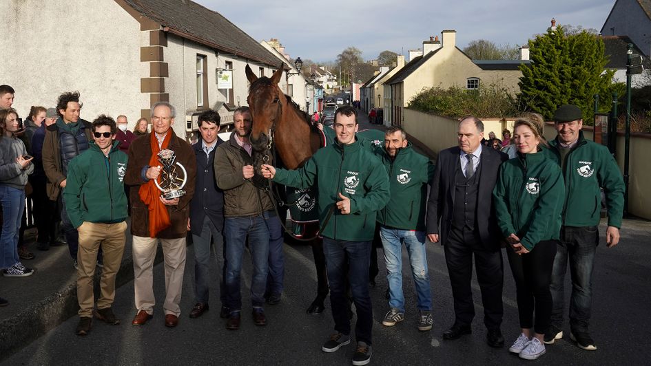 Sam Waley-Cohen (left), his father Robert Waley-Cohen (second left), trainer Emmet Mullins (third left) and others pose for photos outside the Lord Bagenal Inn during their homecoming parade in County Carlow