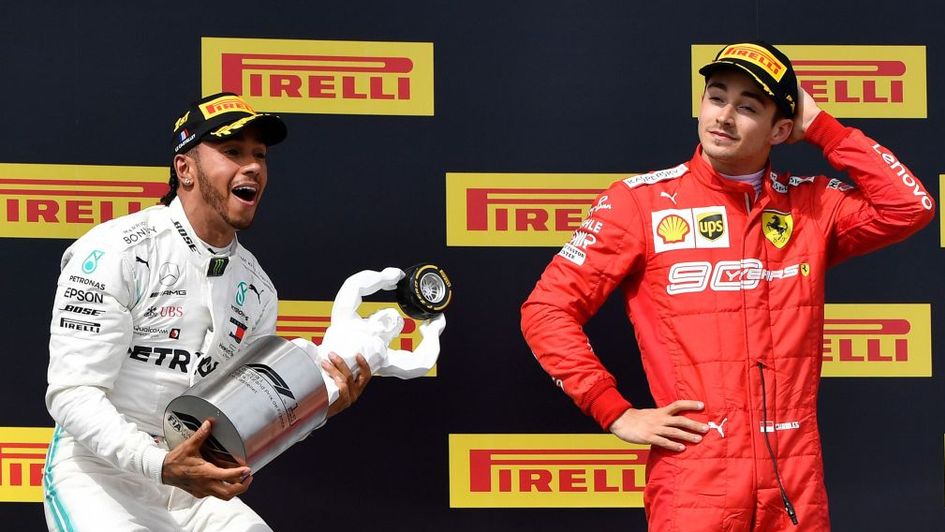 Lewis Hamilton celebrates with Charles Leclerc looking on
