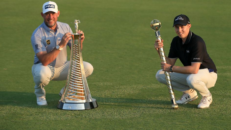 Matthew Fitzpatrick (right) with the DP World Tour Championship trophy alongside Lee Westwood with the Race to Dubai Trophy