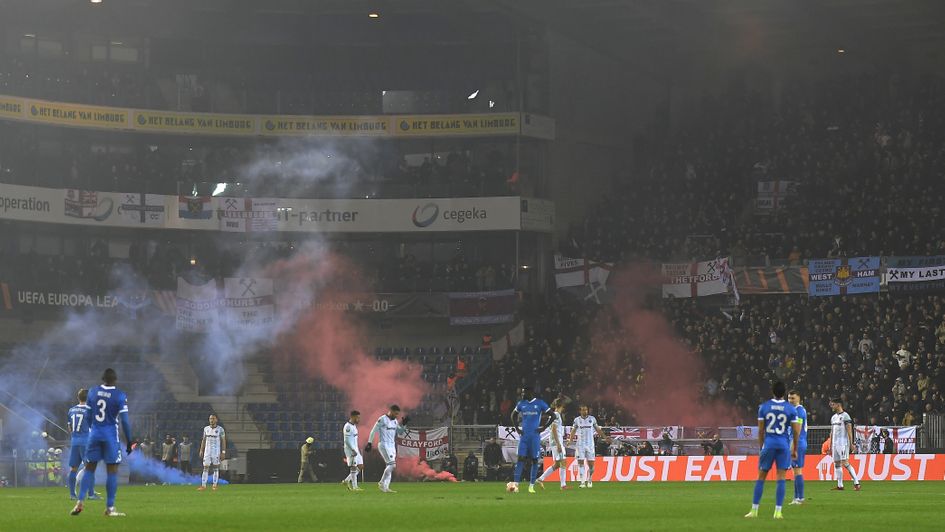 Smoke bombs are thrown onto the pitch after West Ham United score their first goal during the UEFA Europa League match against Genk