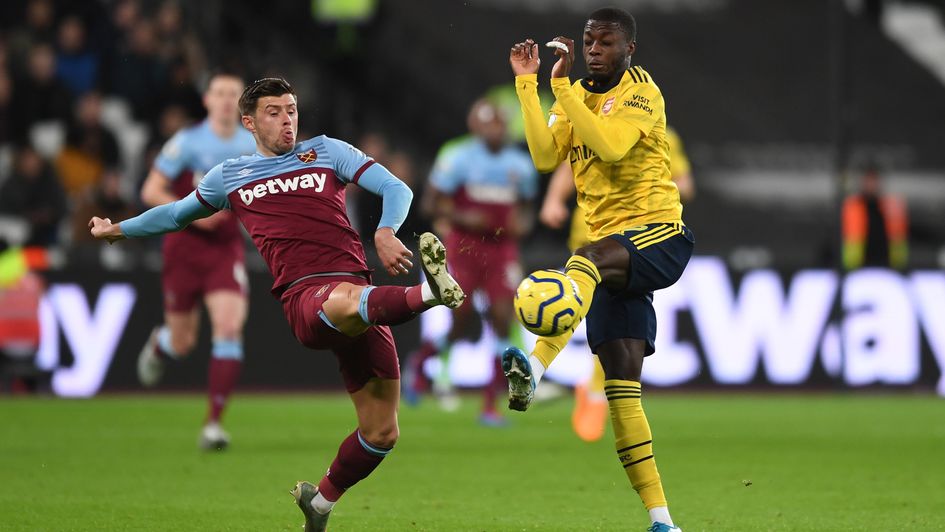 West Ham's Aaron Cresswell (left) goes in for a challenge with Nicolas Pepe of Arsenal