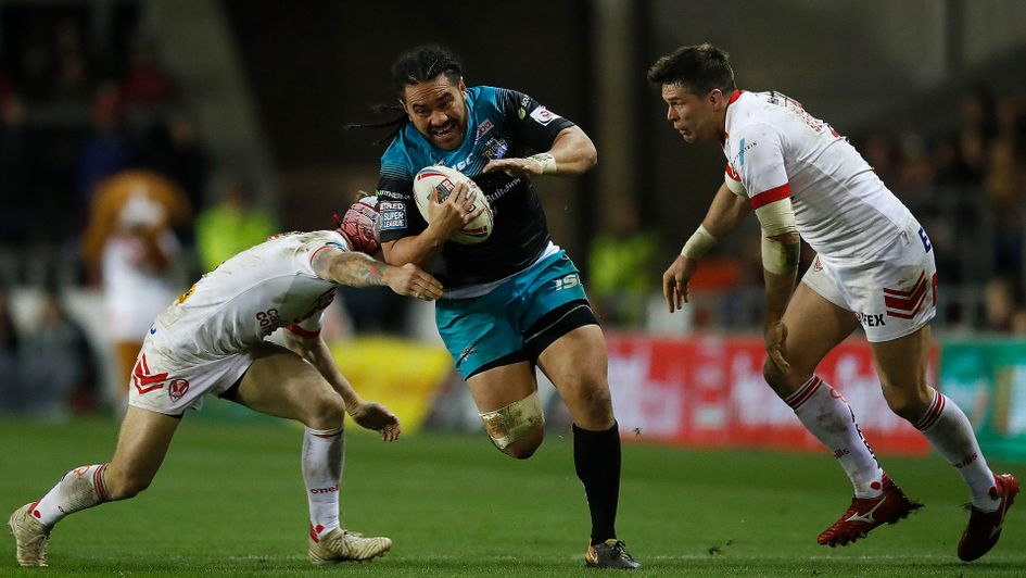 Leeds Rhinos' Konrad Hurrell is tackled by St Helens Saints' Theo Fages (left) and Louie McCarthy-Scarsbrook (right)