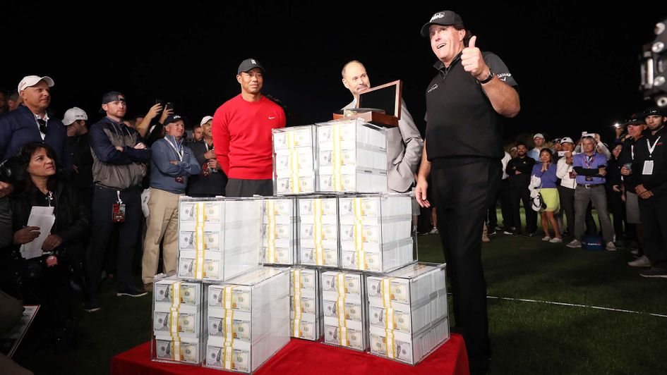 Phil Mickelson celebrates with nine million dollars after beating Tiger Woods