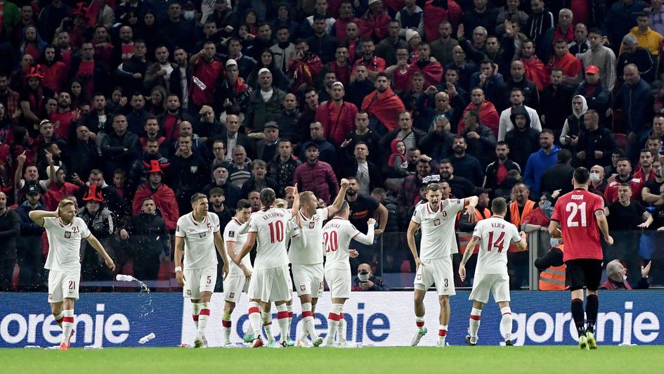 Poland players protect themselves from objects being thrown from the stands