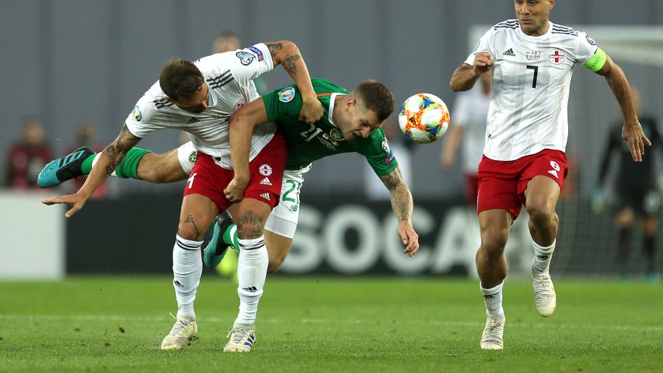 Georgia's Guram Kashia (left) and Republic of Ireland's James Collins (centre) battle for the ball