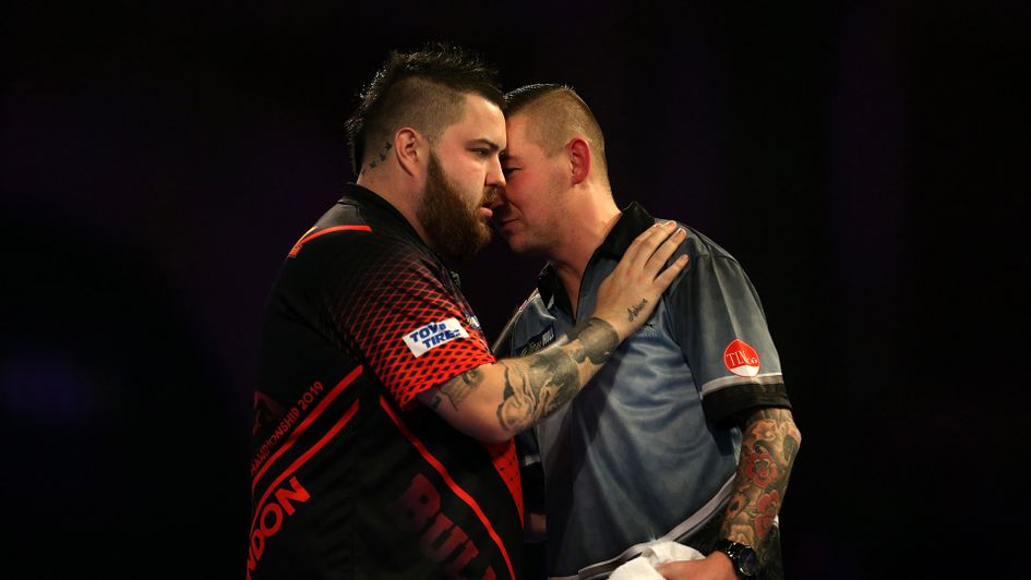 Michael Smith hugs Nathan Aspinall after their thrilling showdown