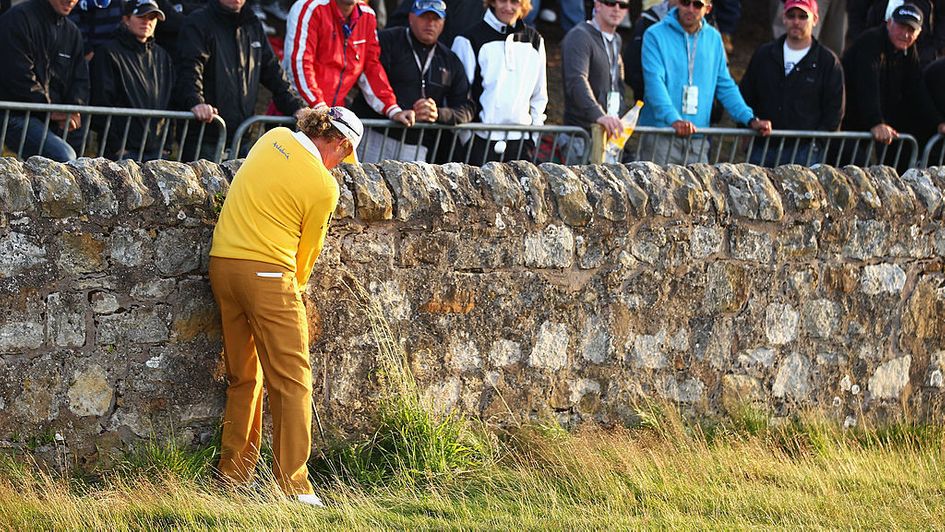 Miguel Angel Jimenez uses the wall to his advantage beside the 17th green
