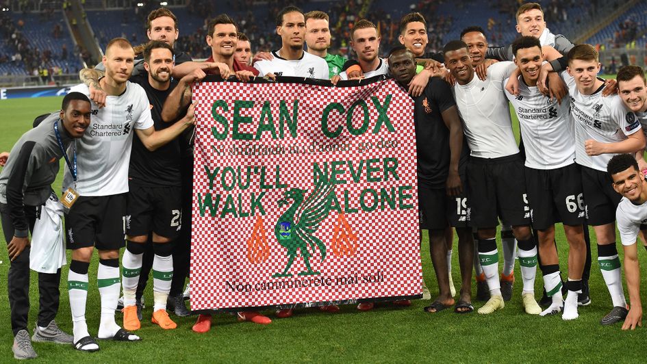 Liverpool players hold a banner in support of Sean Cox