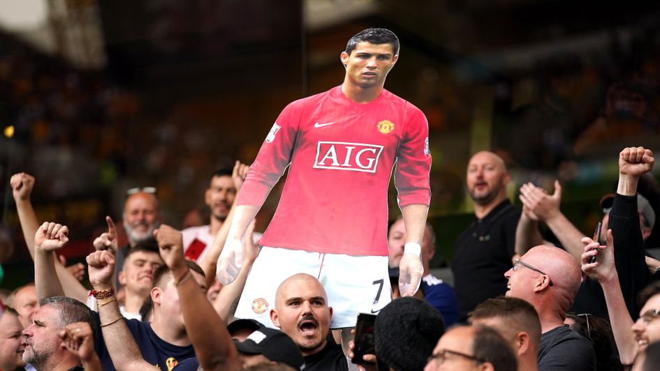 Manchester United fans hold up a cardboard cutout of Ronaldo